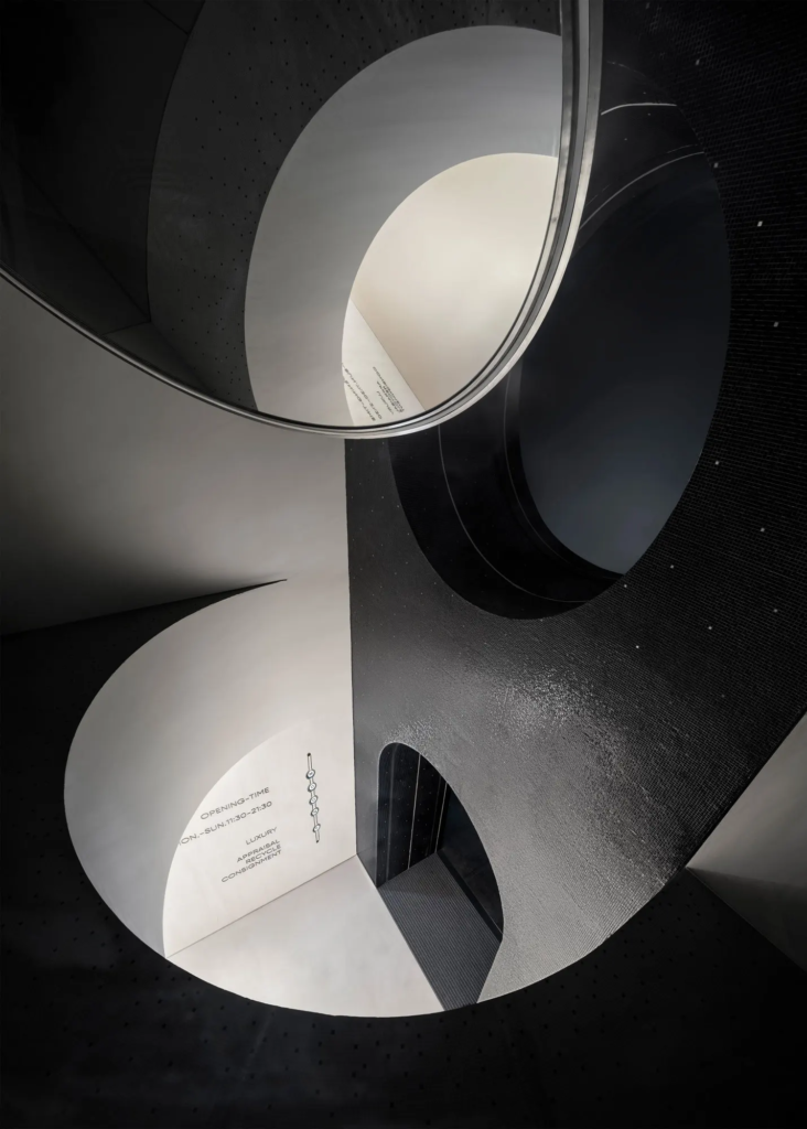 Transition from bright white mosaic surfaces to immersive dark architectural space