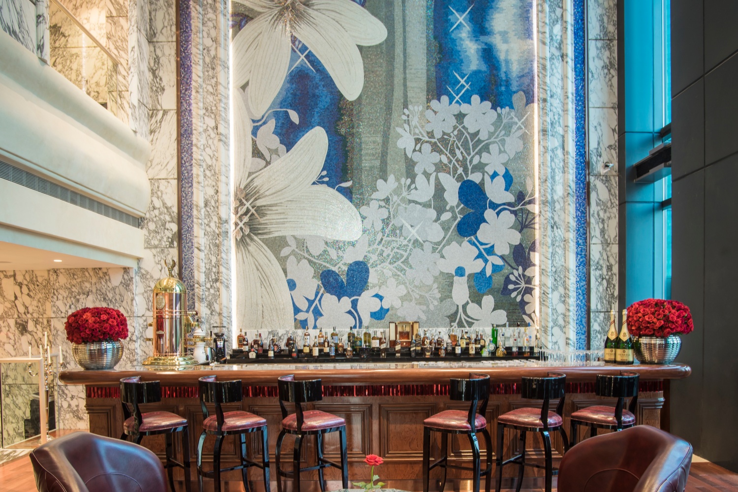 Luxury hotel bar interior featuring custom artistic glass mosaic wall by JNJMosaic