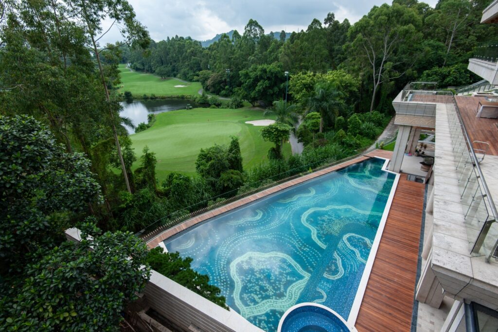 How to Choose Pool Mosaic Tiles: A Project-Based Guide 5 Outdoor swimming pool with a custom blue mosaic pattern integrated into the surrounding landscape