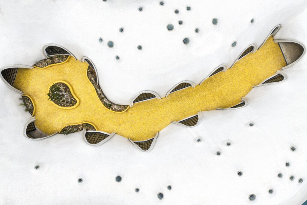 Aerial view of a yellow mosaic corridor flowing through the cloud-like architecture