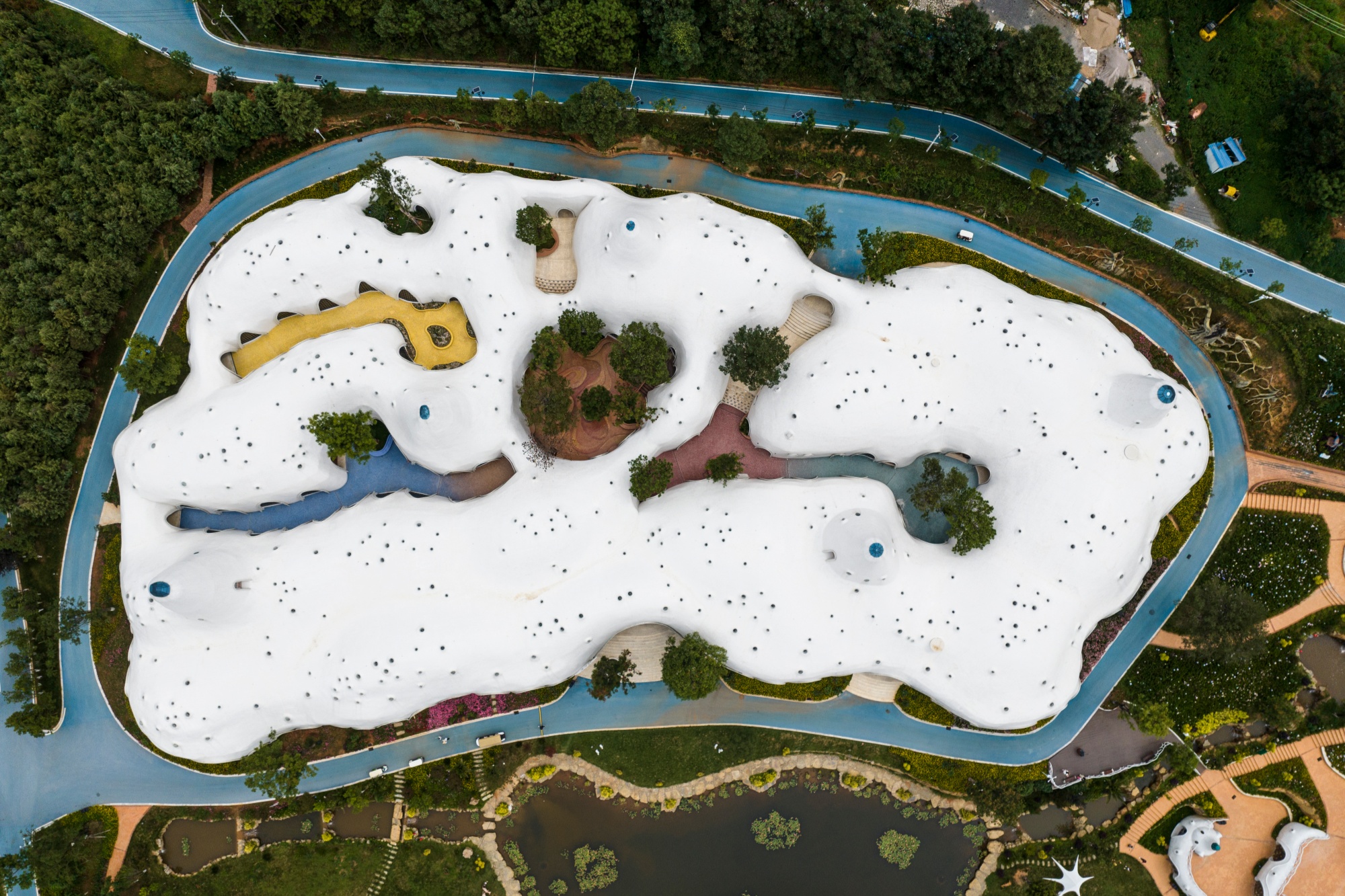 Top-down aerial view of The Cloud Art Palace and its colorful mosaic corridors in Yunnan