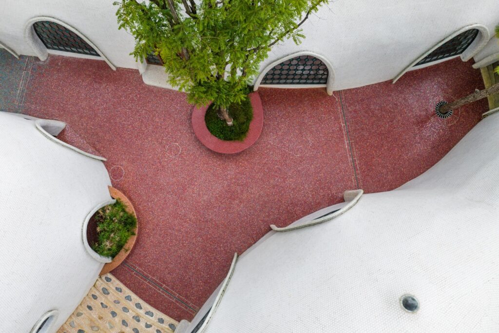 Aerial view of a magenta mosaic corridor winding through the cloud-like architecture