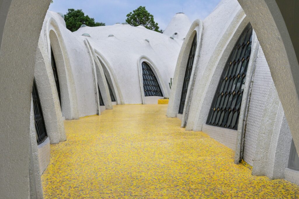 Yellow glass mosaic corridor between sculptural white walls at The Cloud Art Palace