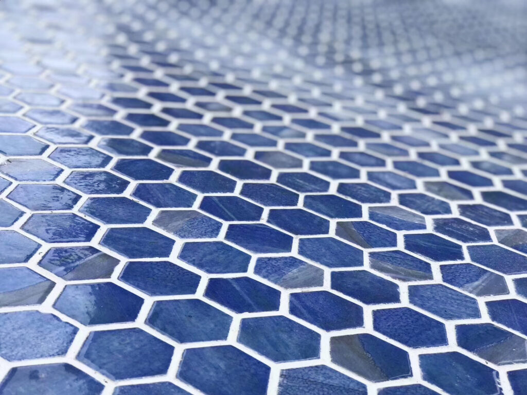 How to Choose Pool Mosaic Tiles: A Project-Based Guide 10 Close view of blue hexagonal pool mosaics showing tile size, surface variation and grout joints