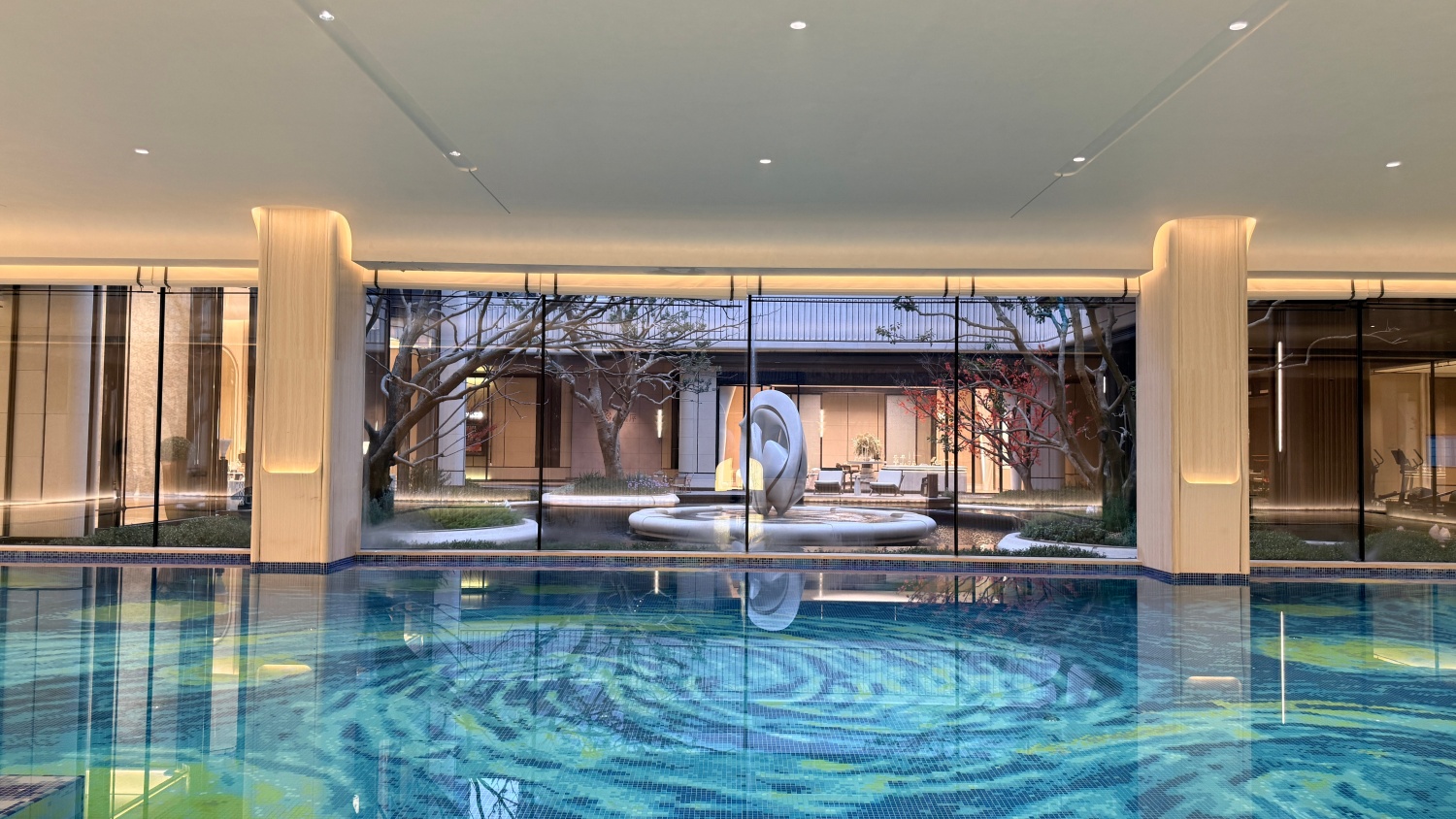 Artistic pool mosaic reflecting the landscaped clubhouse courtyard