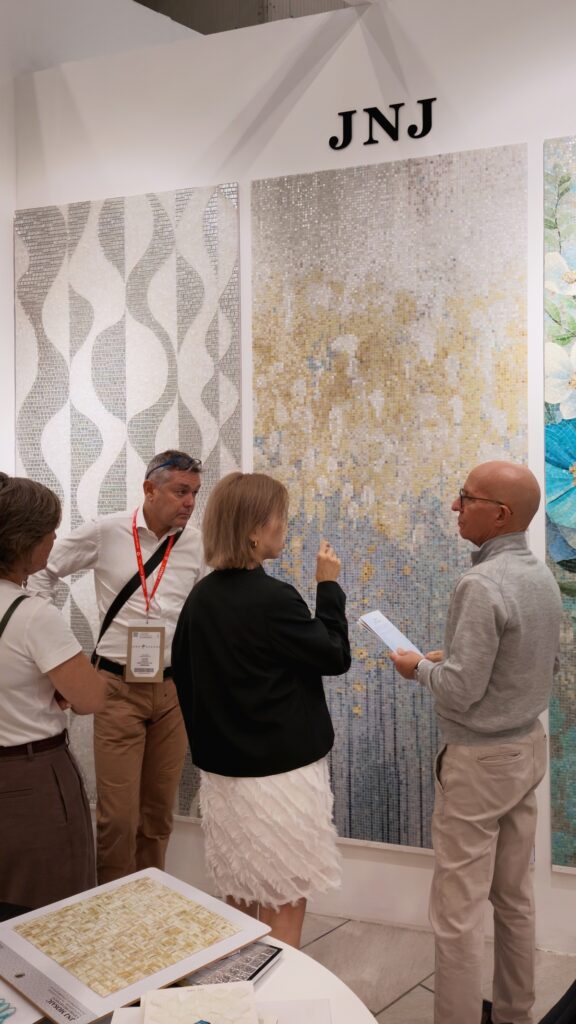 Visitor and JNJ representative discussing a blue floral mosaic mural