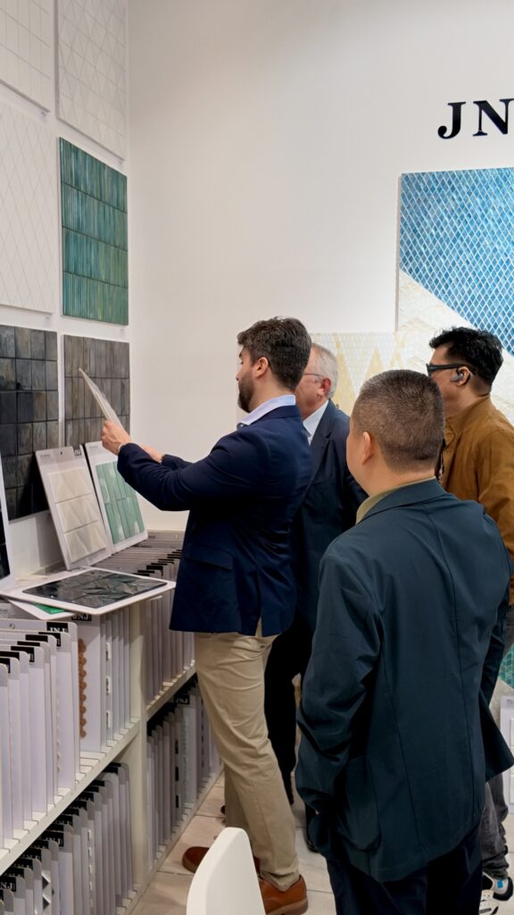Inside the JNJMosaic Booth at Cersaie 2026: Art, Materials and Meaningful Conversations 7 Visitors comparing mosaic samples and catalogues at Cersaie 2026
