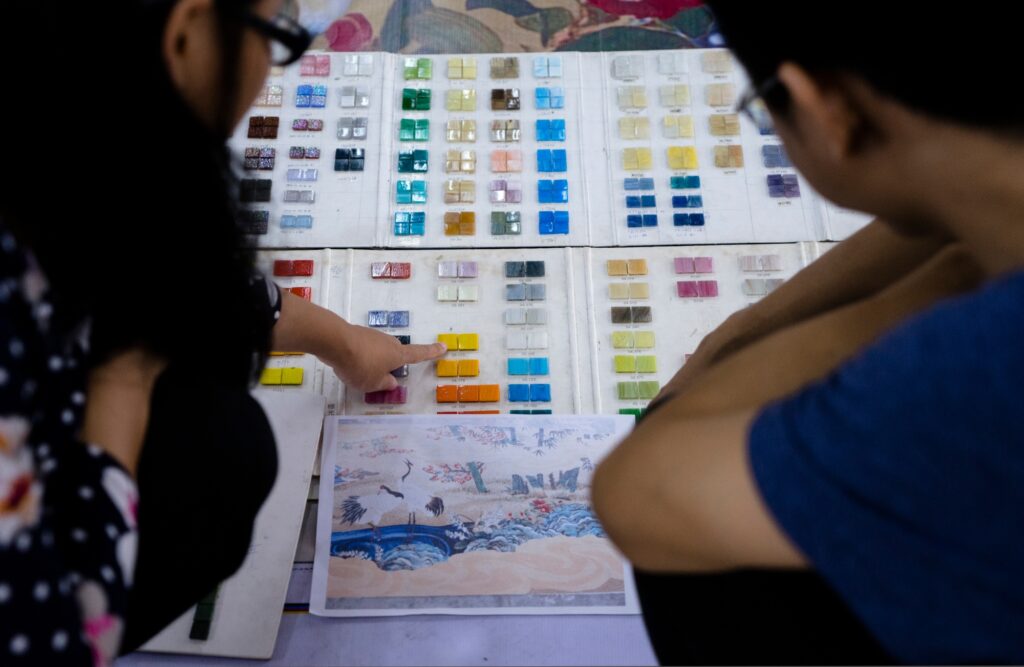 Custom Mosaic Tiles: From Design to Production 2 Selecting mosaic colors from physical sample boards alongside the artwork reference