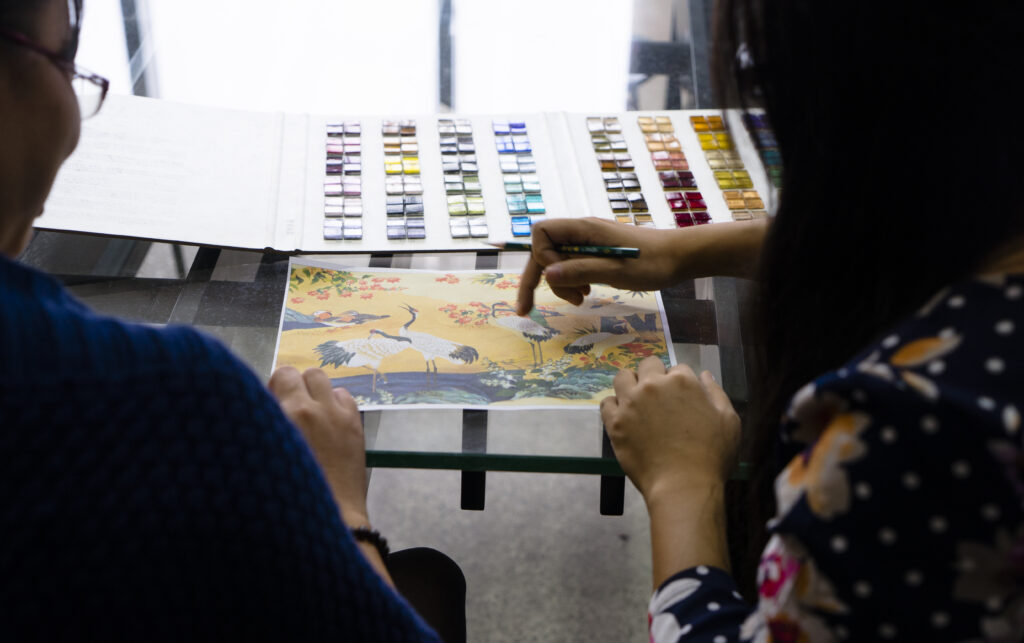 Custom Mosaic Tiles: From Design to Production 3 JNJMosaic team reviewing mosaic color samples and reference artwork together