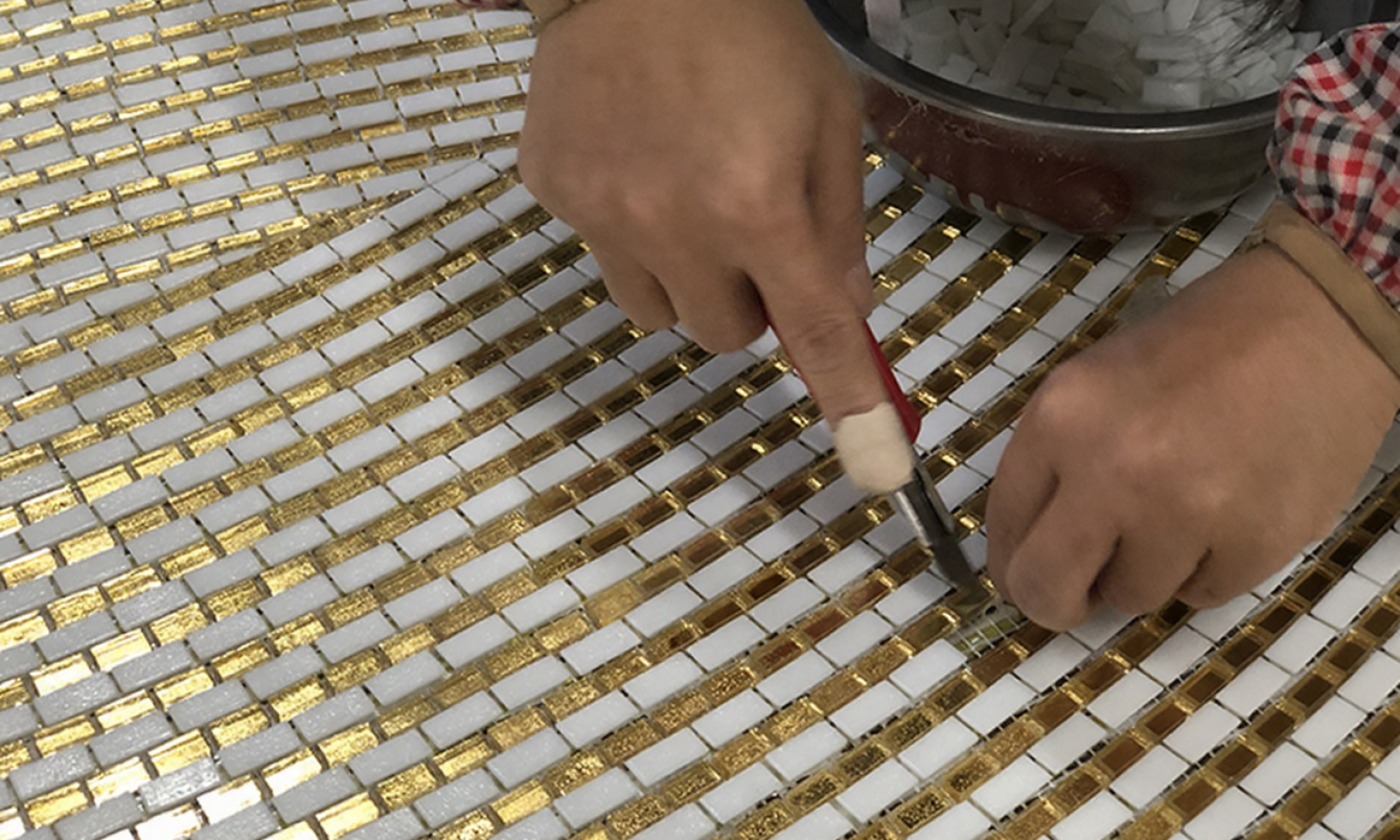 Expert mosaic artisan performing precise on-site manual adjustment and installation for curved walls