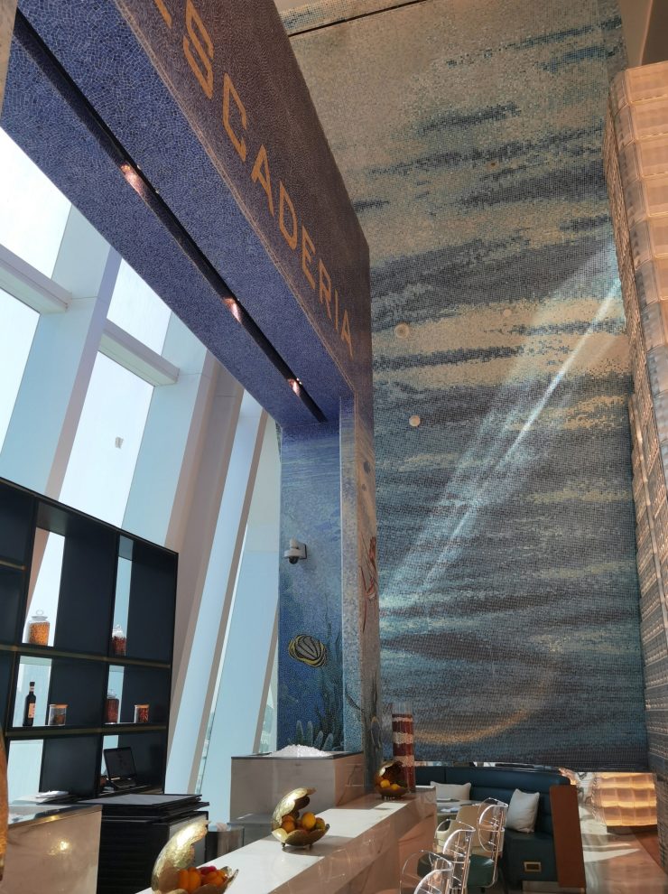 Immersive ocean theme restaurant interior with custom marine life mosaic walls and Arabian Gulf views