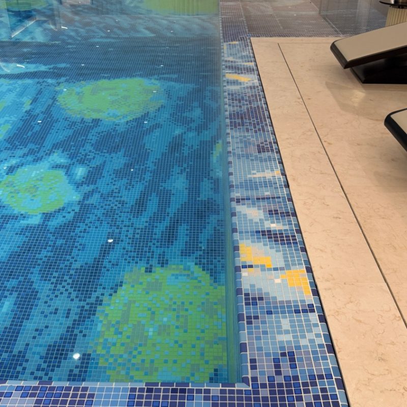 Custom blue mosaic detailing along the clubhouse swimming pool edge